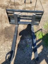 Skid loader mounted pallet forks