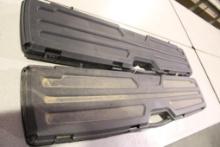 Two black plastic rifle/shotgun cases with no padding