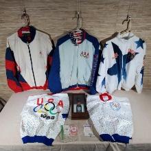 5 1980-1990s Olympic Collectible Jackets, 2 Decks of Cards and Bottle in Display Case