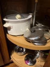 contents of kitchen cabinet crockpot pan lids and miscellaneous