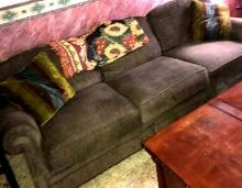 Brown couch with pillows/throw