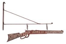 DESIRABLE PAINTED WINCHESTER ARMS AND AMMUNITION TRADE SIGN WITH BRACKET.