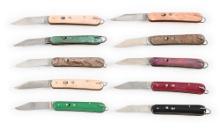 LOT OF 10: EDGEMASTER AUTOMATIC KNIVES IN DISPLAY CASE.