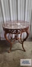 Antique carved stand with marble top. 30 in. tall by 28 in. round