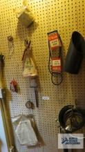 Ratchet strap, assorted hoses, v-belts, leather punch and etc on pegboard