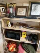 Contents in bookcase. Microwave, framed wall art, vests, vases,etc